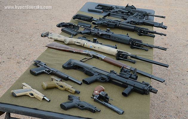 拳銃とライフルをテーブルの上にずらりと並べる